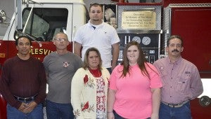 Members of the Maplesville Fire Department surprised Perrin (center in pink) Saturday night with a gold plaque placed on the truck that states the plaque is dedicated "in memory of Tim Mims for oustanding support for Maplesville Volunteer Fire Department Dec. 14, 2013."