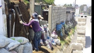 Natives of Guatemala City help the mission group work on a retaining wall, which will help keep homes safe during monsoon rains.