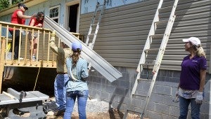 The group of volunteers worked to add vinyl siding to the home so insulation could be installed on Thursday.