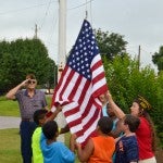 Crishuna Oliver, Zachary Geiger, Jontae Franklin, Isaiah Foster and Malcolm Lezama help Bonny Cost raise a new American Flag at the Chilton County YMCA on Friday.