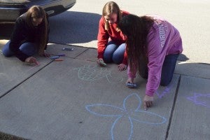 Friends Marissa Muir, Savannah Parrish and Jessalyn Davis drew butterflies, turtles and flowers on the sidewalk.